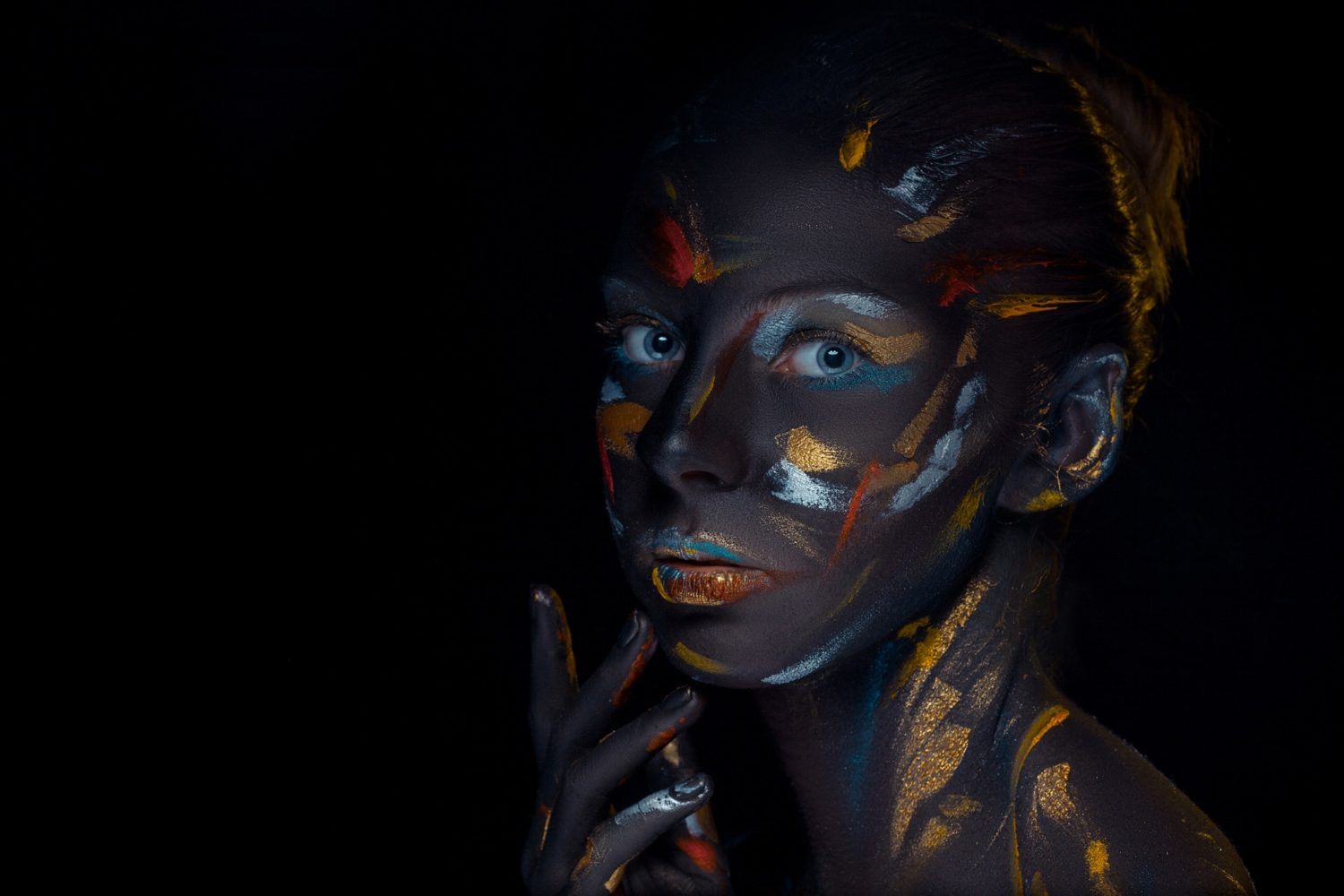 Portrait of a young woman who is posing covered with black paint